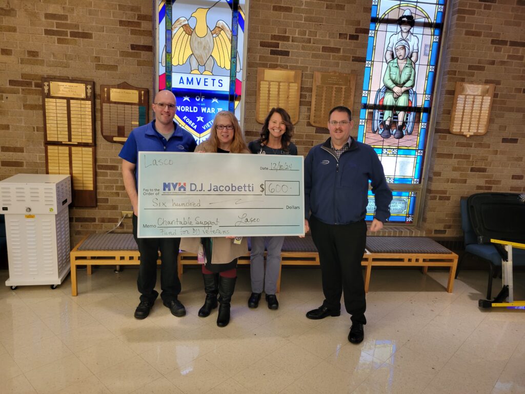 Four people hold a large mock check.